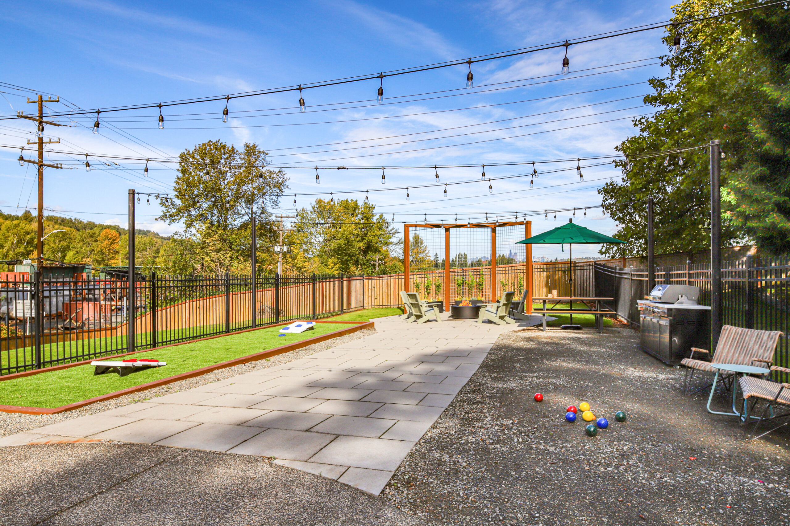 With BBQ stations, a fire pit, pool access, and lawn games, this outdoor area brings the feeling of a shared backyard.