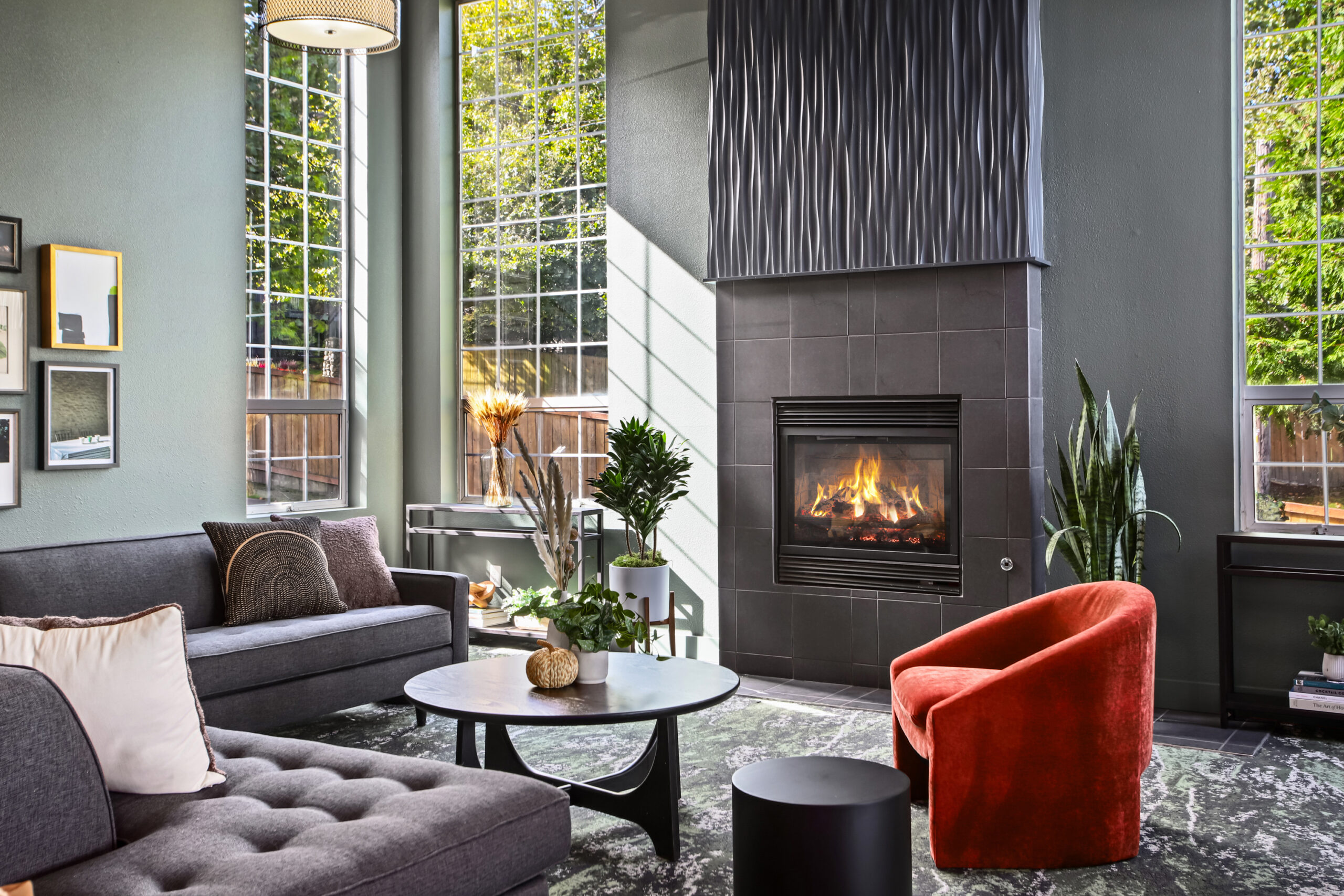 Comfortable armchairs, sofas, and cozy corners surround a central fireplace, the perfect spot for quiet reading or casual connection.